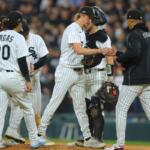 Chicago White Sox relief pitcher Erick Fedde, middle, hands the game ball to manager Will Venable, right, for a pitching change during the fifth inning of Game 4 of baseball's American League Division Series against the Cleveland Guardians, Thursday, Oct. 8, 2026, in Chicago. (AP Photo/Melissa Tamez)
