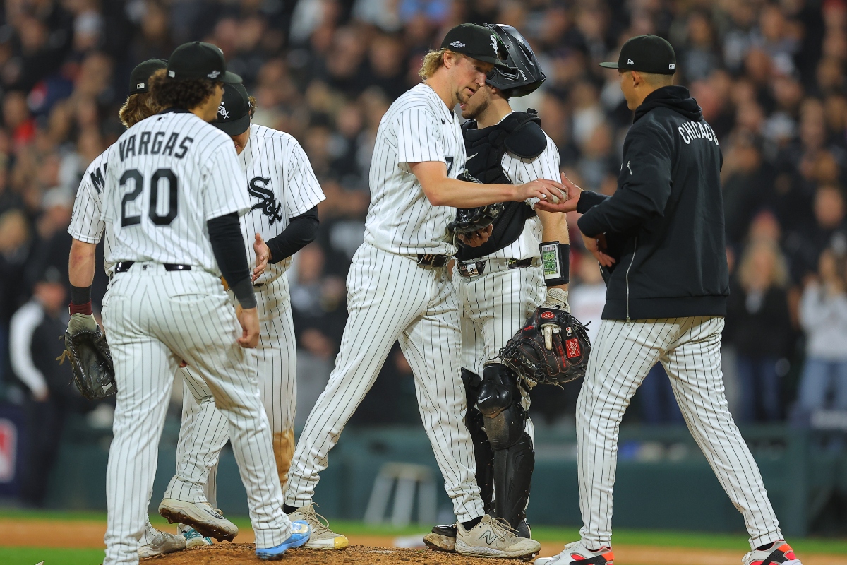 Chicago White Sox relief pitcher Erick Fedde, middle, hands the game ball to manager Will Venable, right, for a pitching change during the fifth inning of Game 4 of baseball's American League Division Series against the Cleveland Guardians, Thursday, Oct. 8, 2026, in Chicago. (AP Photo/Melissa Tamez)