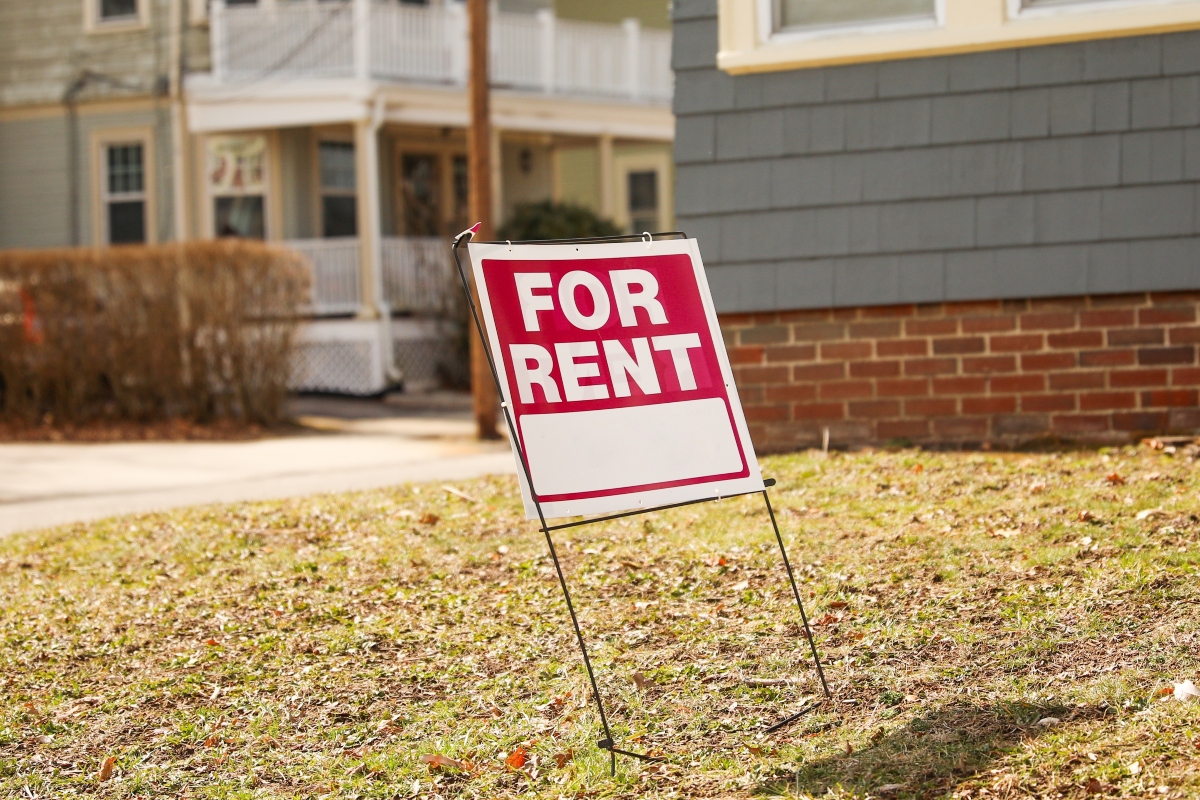For sale for rent sign in front of home showing economic signs of increased inflation and mortgage rates depicting housing market crisis and financial troubles