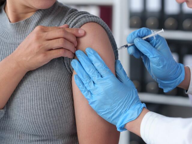 Hands of a male doctor or professional nurse in medical gloves injecting antiviral medicine to a patient. treatment concept medical services.