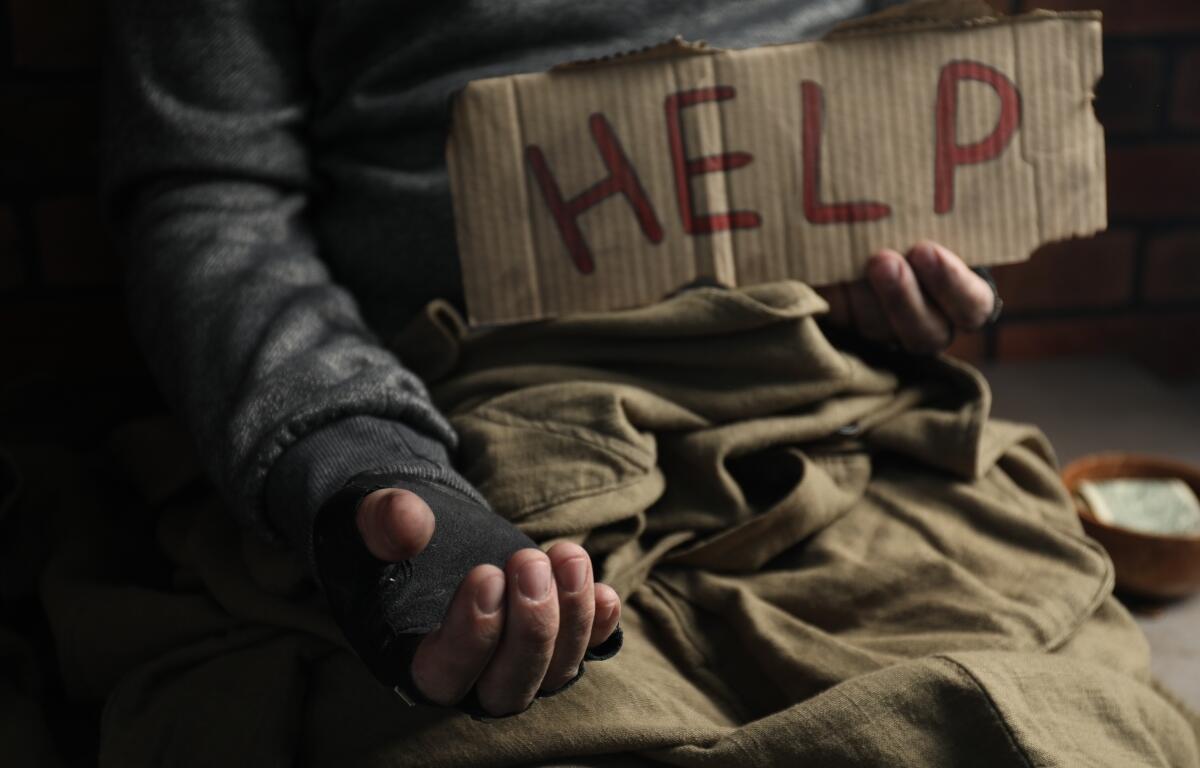 Poor homeless man with help sign begging for money, closeup. Charity and donation