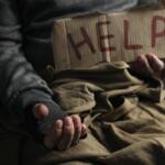 Poor homeless man with help sign begging for money, closeup. Charity and donation