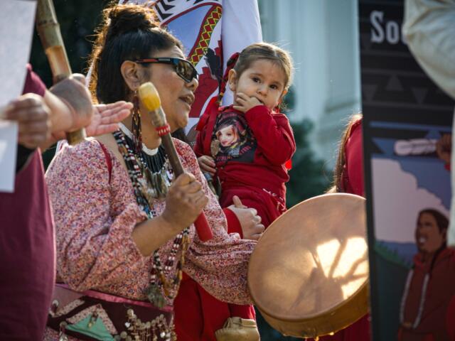 Sacramento, CA, U.S.A. - FEB. 13, 2024: A woman drums and sings during a song at the Missing and Murdered Indigenous Peoples Day of Action at the state capitol.