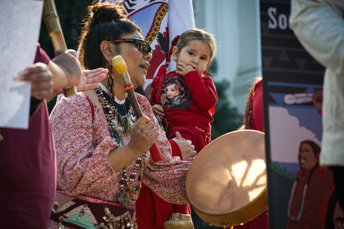 Sacramento, CA, U.S.A. - FEB. 13, 2024: A woman drums and sings during a song at the Missing and Murdered Indigenous Peoples Day of Action at the state capitol.