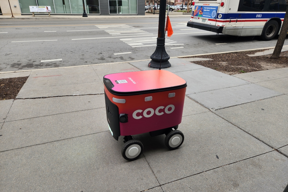 Chicago, IL April 17, 2025, Coco food delivery robot cart going down the sidewalk, automated